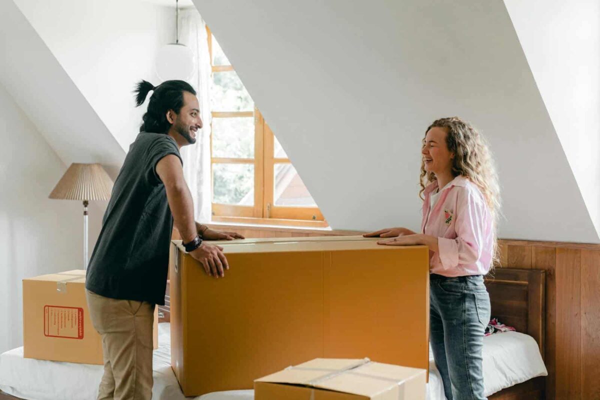 A cheerful couple unpacking boxes in their new apartment, enjoying the moving process.